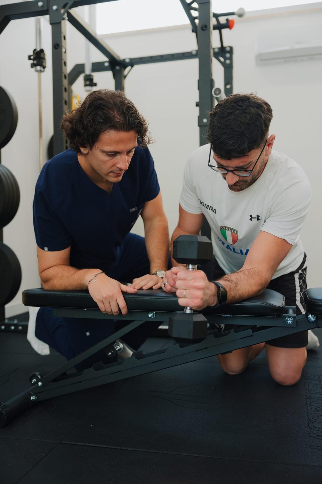 Esercizio di rinforzo degli arti superiori guidato in palestra riabilitativa