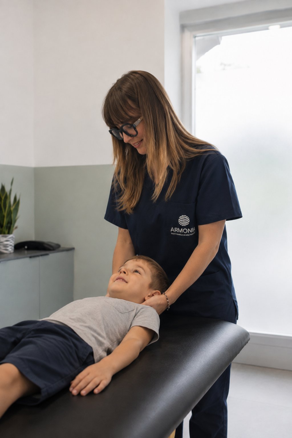 Osteopata di ARMONIA durante una valutazione delicata del collo di un bambino sul lettino